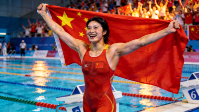 中国游泳运动员张雨霏在女子200米蝶泳夺冠后庆祝，身披国旗